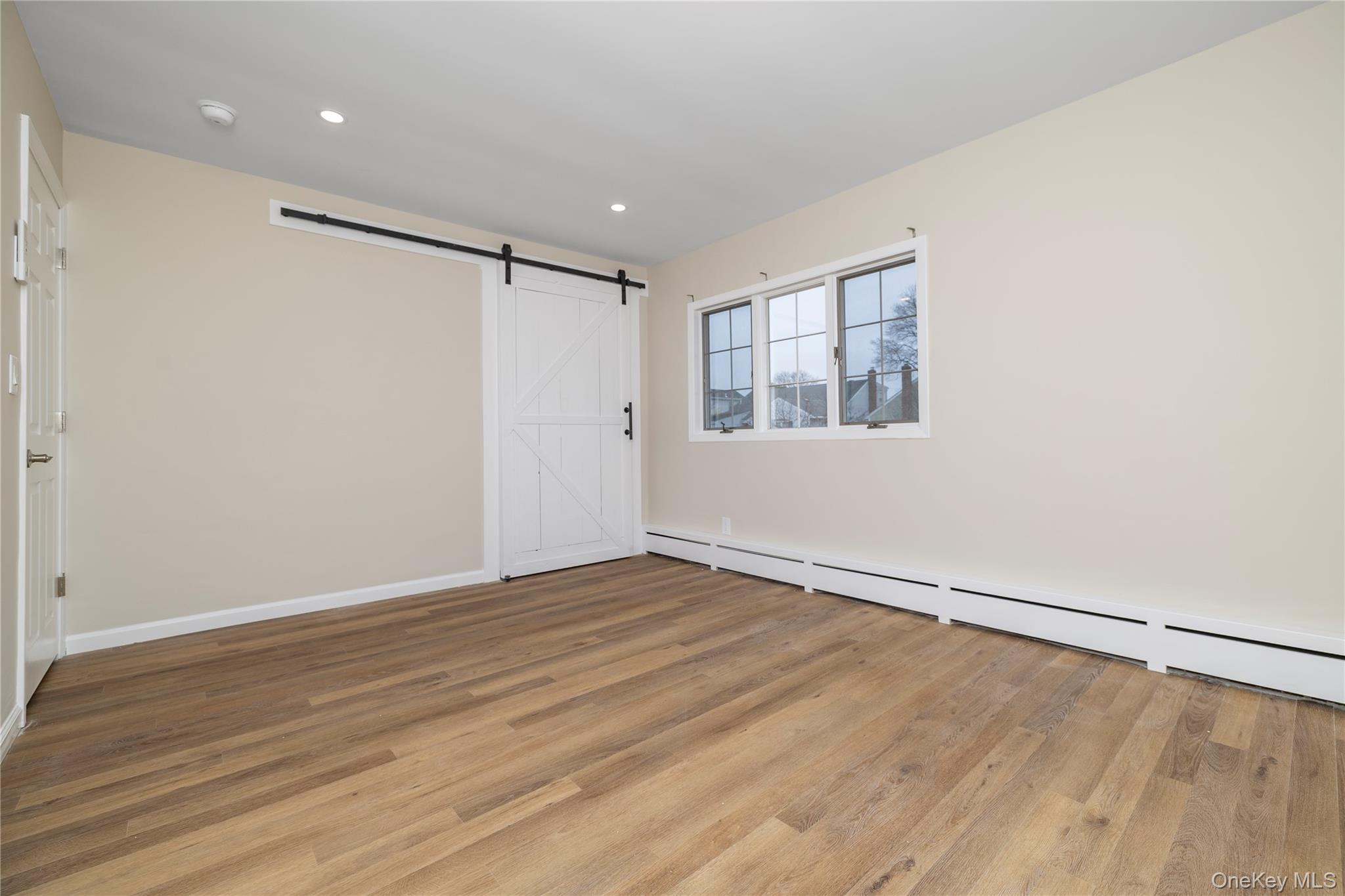 485 Farm Ranch Road West Bethpage, NY 11714 - Photo 15 of 26 Bright and Sunny Primary Bedroom with New Flooring, New Lights, and Barn Door Closet