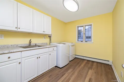 a room with a sink wooden floor and cabinets