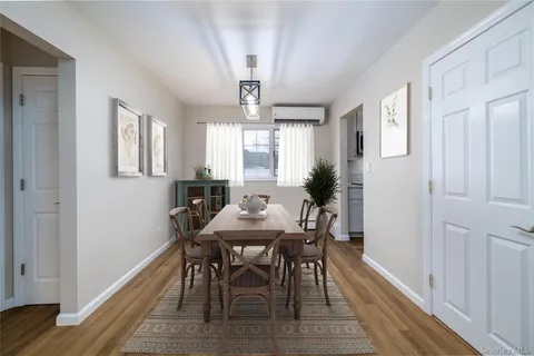 a view of a a dining room with furniture window and wooden floor