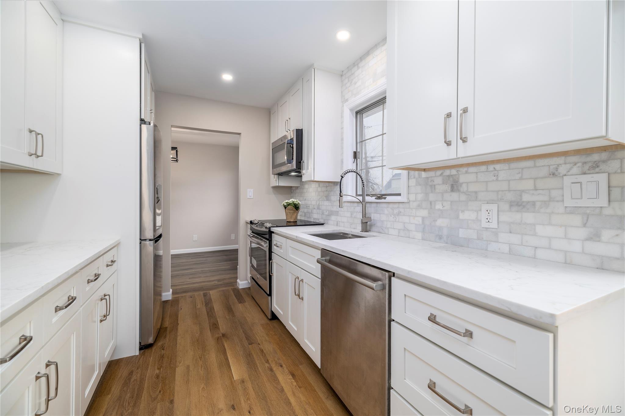 485 Farm Ranch Road West Bethpage, NY 11714 - Photo 10 of 26 Newly Renovated Galley Kitchen with New White Cabinets, Quartz Countertops and Stainless Steel Appliances