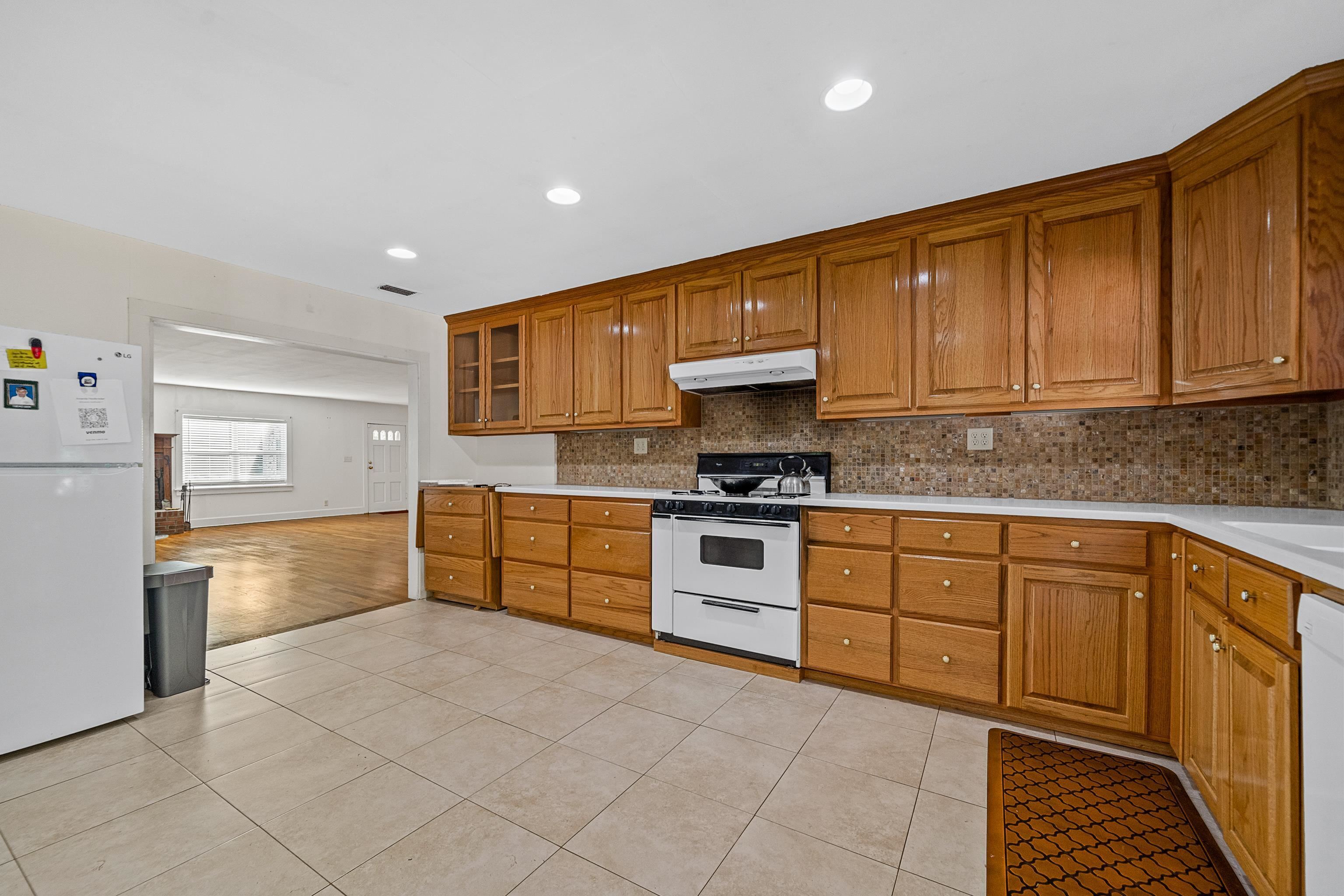 9350 Tompkins Road Stockton, AL 36579 - Photo 25 of 36 Kitchen with white appliances, brown cabinets, backsplash, light tile patterned floors, and recessed lighting