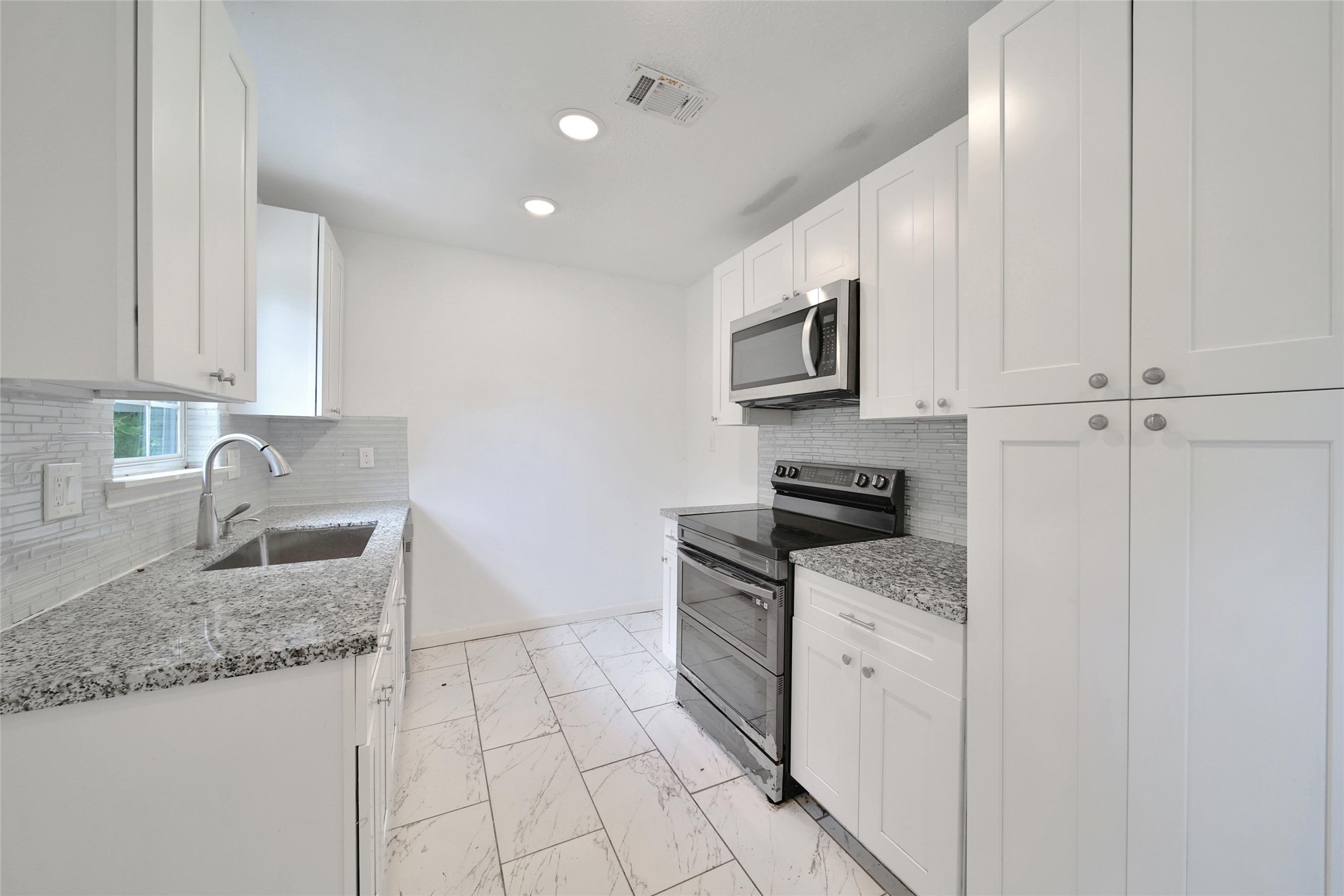 7346 Calais Road Houston, TX 77033 - Photo 4 of 9 a kitchen with granite countertop a sink stove and cabinets