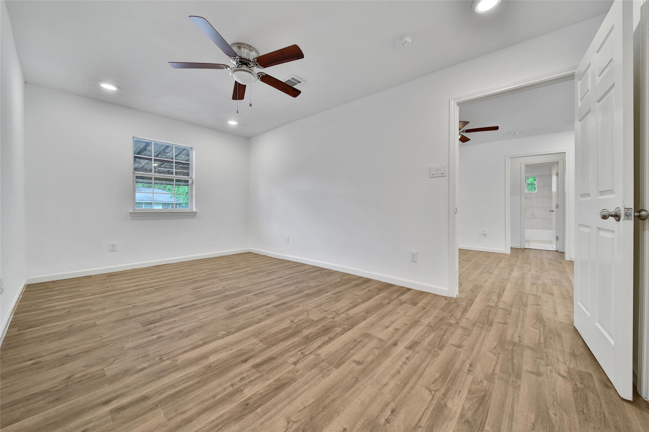 7346 Calais Road Houston, TX 77033 - Photo 7 of 9 wooden floor in an empty room with a window
