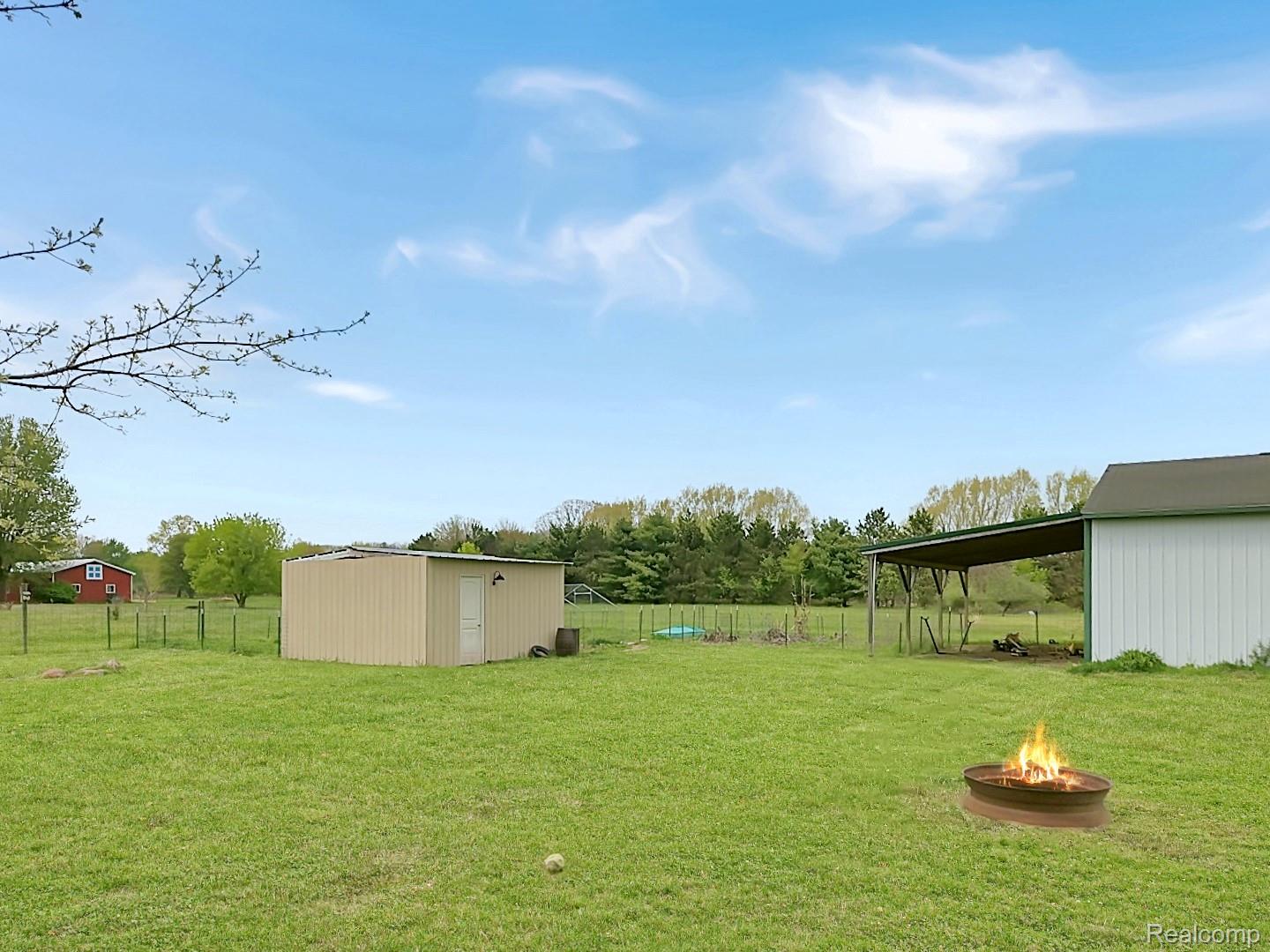 6533 Kilburn Road Jeddo, MI 48032 - Photo 3 of 19 View of yard with an outbuilding and an outdoor fire pit