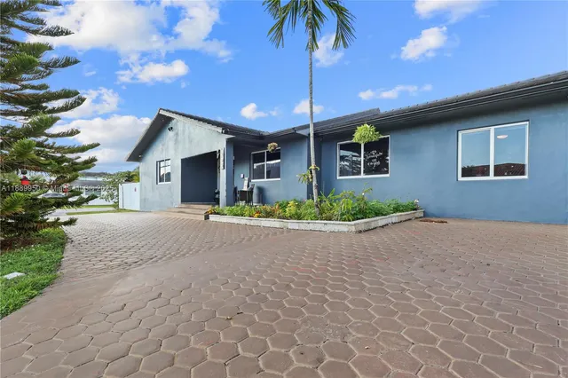 a view of a house with a yard and potted plants