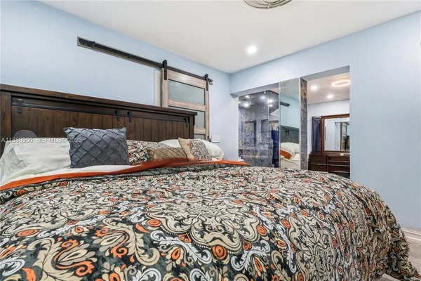 a bed sitting in a bedroom and view of kitchen