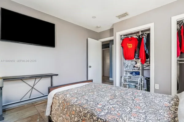 a bedroom with a bed and a flat screen tv