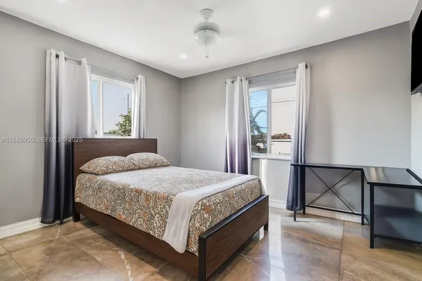 a bedroom with a bed wooden floor and window