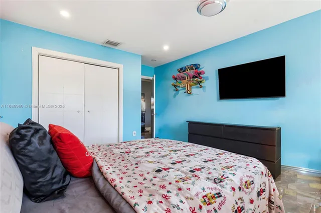 a bedroom with a bed and a flat screen tv