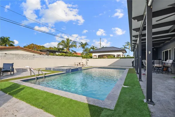 a view of a swimming pool with lawn chairs with plants