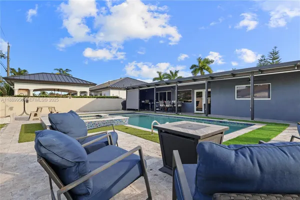 a view of a house with swimming pool and sitting area