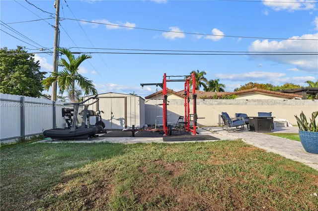 a view of a backyard with couches under an umbrella