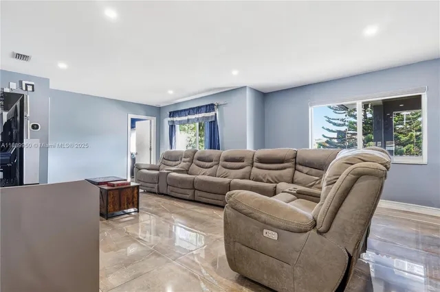 a living room with furniture a large window and a wooden floor