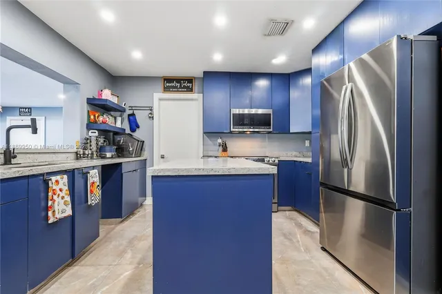 a kitchen with stainless steel appliances granite countertop a refrigerator and a sink