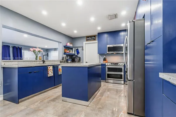a kitchen with stainless steel appliances granite countertop a refrigerator and a stove