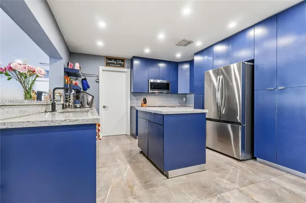 a kitchen with stainless steel appliances granite countertop a refrigerator and a sink