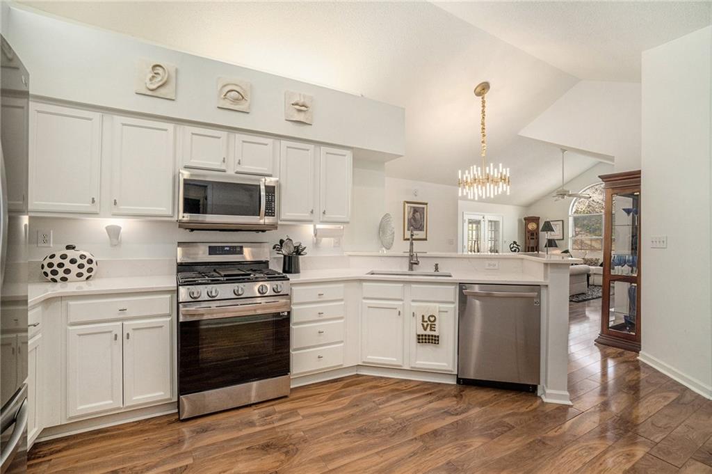 a kitchen with stainless steel appliances a stove sink and white cabinets