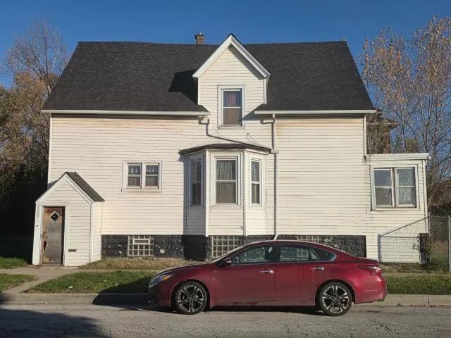 a car parked in front of white house