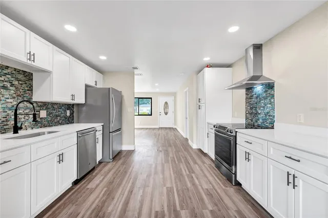 a kitchen with white cabinets and stainless steel appliances