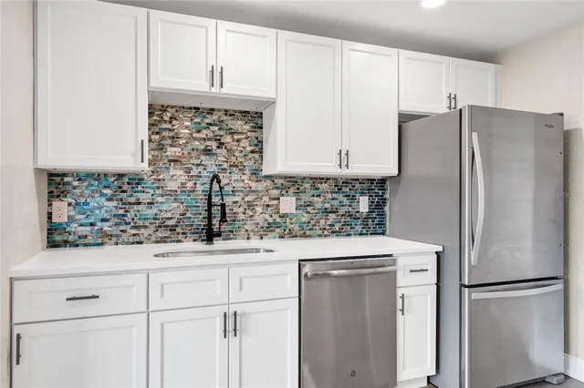 a kitchen with stainless steel appliances white cabinets and a sink