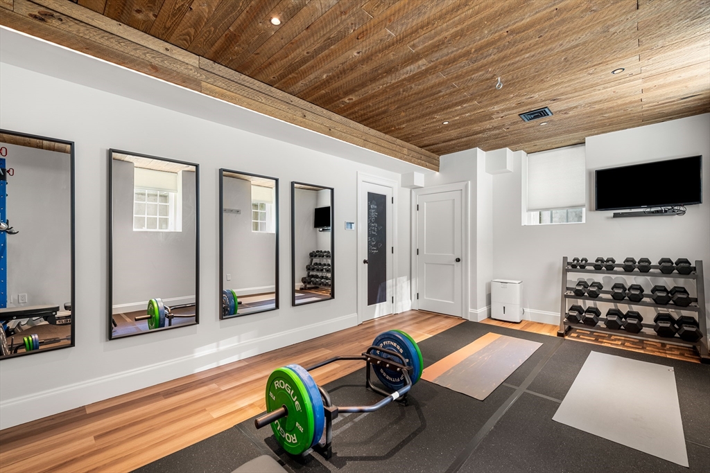 53 Crowninshield Road Brookline, MA 02446 - Photo 42 of 42 a room with furniture gym equipment and flat screen tv