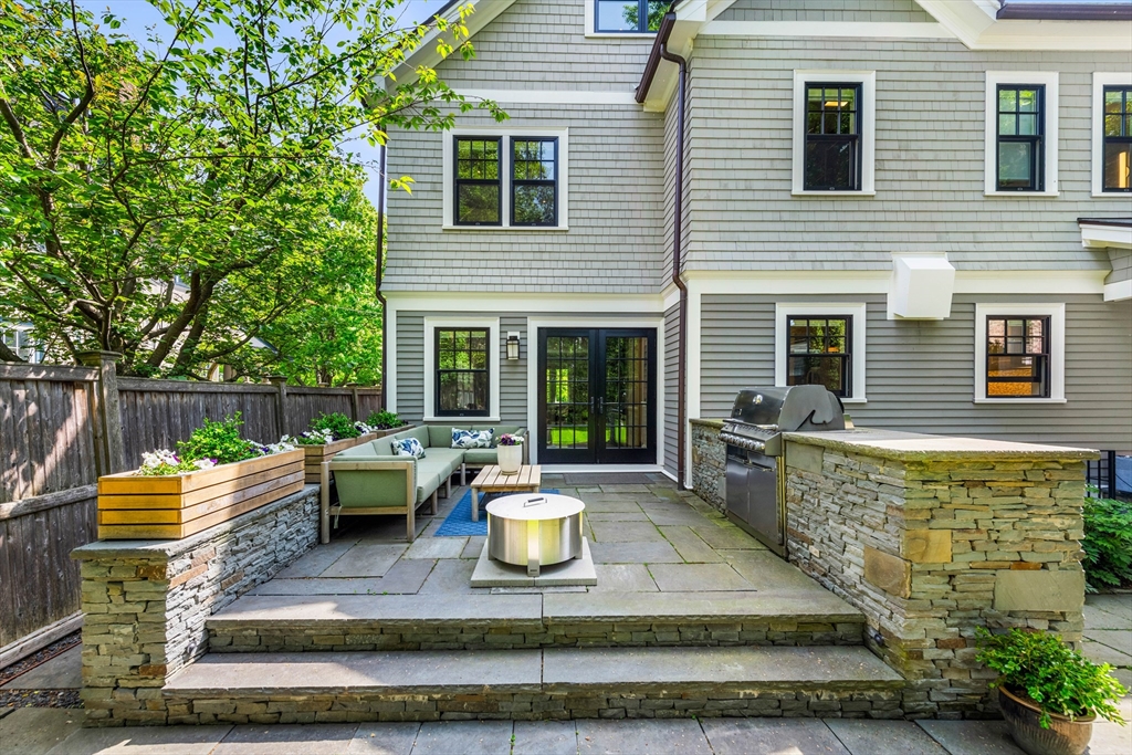 53 Crowninshield Road Brookline, MA 02446 - Photo 6 of 42 a view of a patio with couches chairs and a fire pit