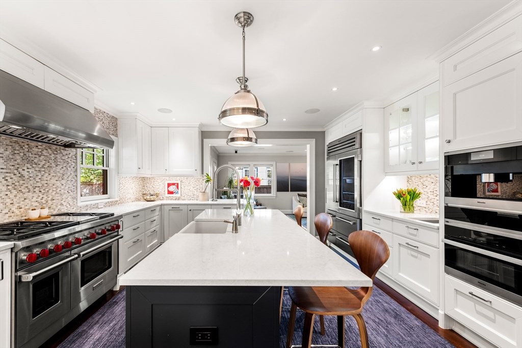 53 Crowninshield Road Brookline, MA 02446 - Photo 9 of 42 a large kitchen with stainless steel appliances a stove center island a window and dining table