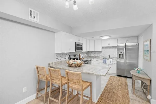 a kitchen with stainless steel appliances kitchen island granite countertop a table and chairs