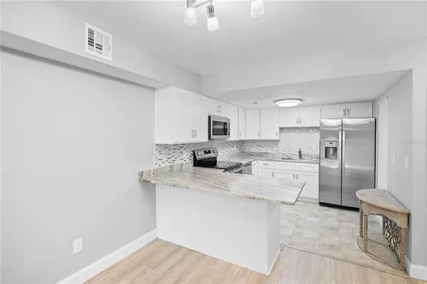 a kitchen with white cabinets and stainless steel appliances