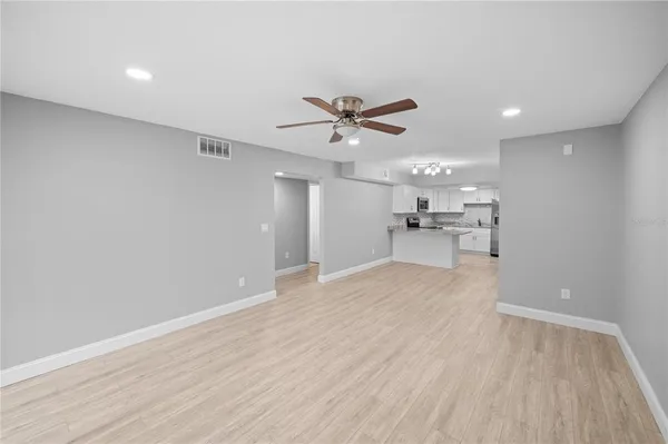 a view of an empty room with a kitchen