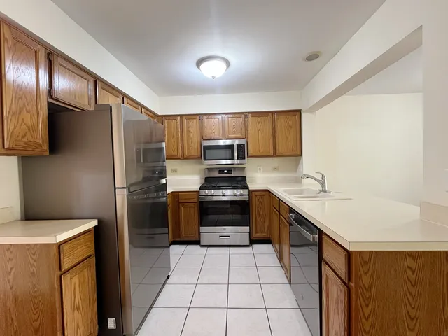a kitchen with a sink a stove top oven and refrigerator