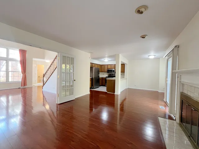 a view of a livingroom with wooden floor and a fireplace