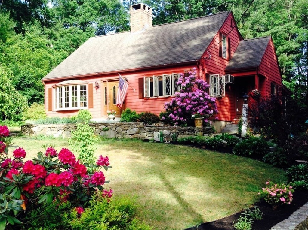 a front view of a house with a yard and fountain