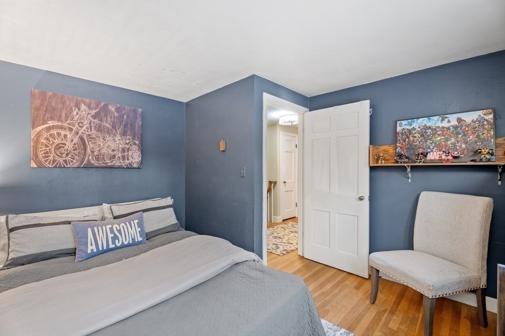 6 Oxford Road Hampstead, NH 03841 - Photo 18 of 32 a bedroom with a bed and a chair with painting on the wall