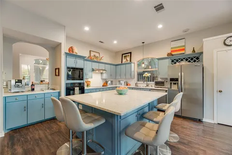 a large kitchen with a table and chairs