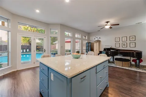 a kitchen with stainless steel appliances granite countertop a refrigerator and wooden floor