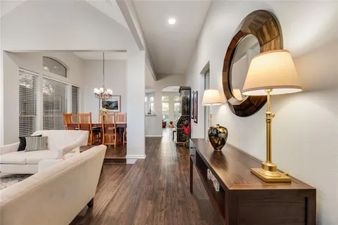 a living room with furniture a mirror and a wooden floor