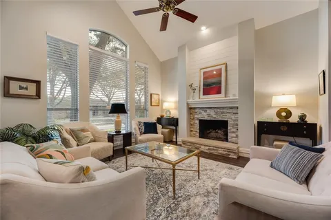 a living room with furniture fireplace and a large window