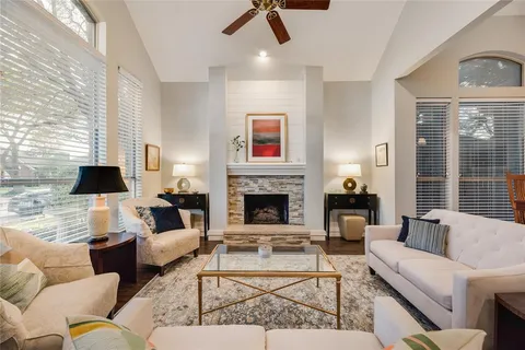 a living room with furniture fireplace and a large window