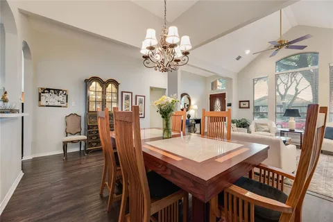 a view of a dining room with furniture a chandelier and wooden floor