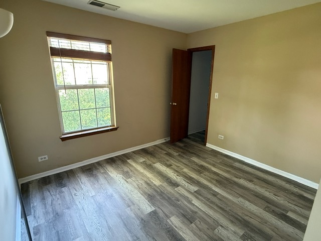 16 Tyler Court, Unit B Streamwood, IL 60107 - Photo 11 of 20 a view of an empty room with wooden floor and a window