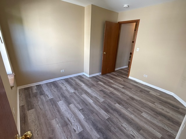 16 Tyler Court, Unit B Streamwood, IL 60107 - Photo 12 of 20 a view of an empty room with wooden floor and a window