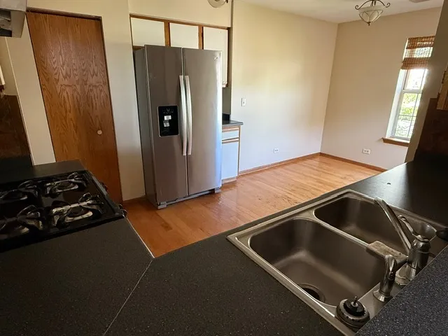 a room with refrigerator and wooden floor