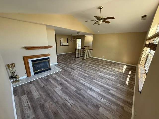 a view of an empty room with a fireplace and a window