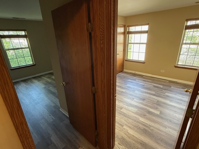 16 Tyler Court, Unit B Streamwood, IL 60107 - Photo 9 of 20 an empty room with wooden floor and windows