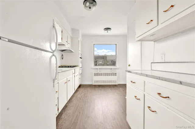 a kitchen with cabinets and wooden floor