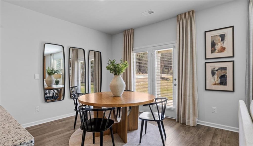 205 Storm Lane Hoschton, GA 30548 - Photo 15 of 51 a view of a dining room with furniture window and wooden floor
