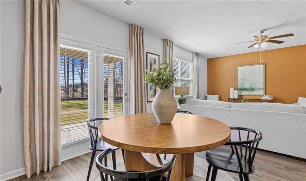 205 Storm Lane Hoschton, GA 30548 - Photo 16 of 51 a view of a dining room with furniture window and wooden floor