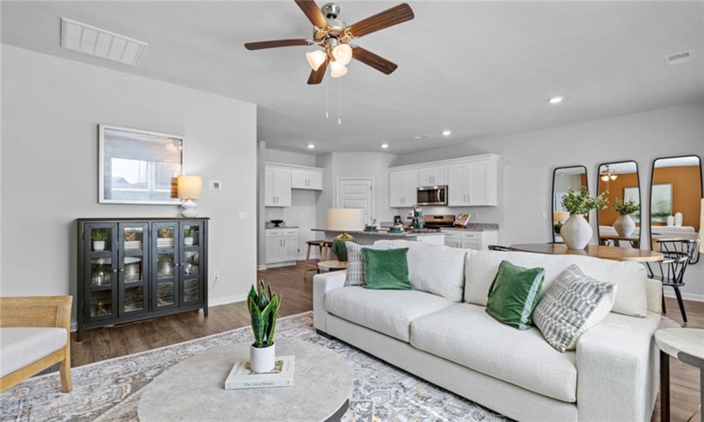 205 Storm Lane Hoschton, GA 30548 - Photo 20 of 51 a living room with furniture kitchen view and a potted plant