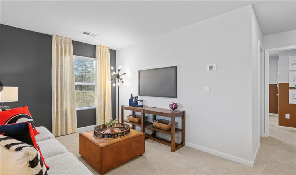 205 Storm Lane Hoschton, GA 30548 - Photo 32 of 51 a living room with furniture and a flat screen tv